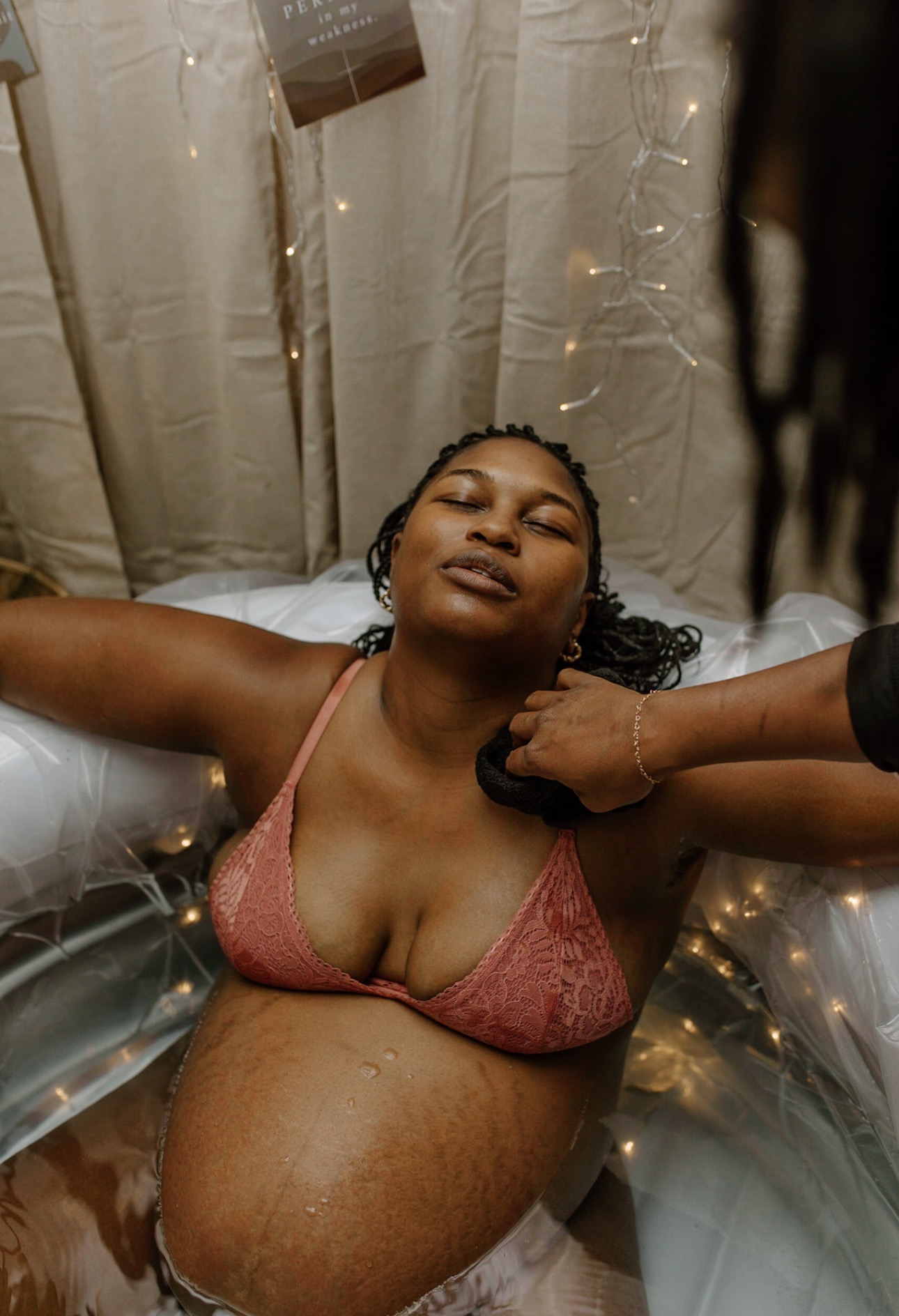 Precious laboring peacefully in the birth pool, supported by her husband